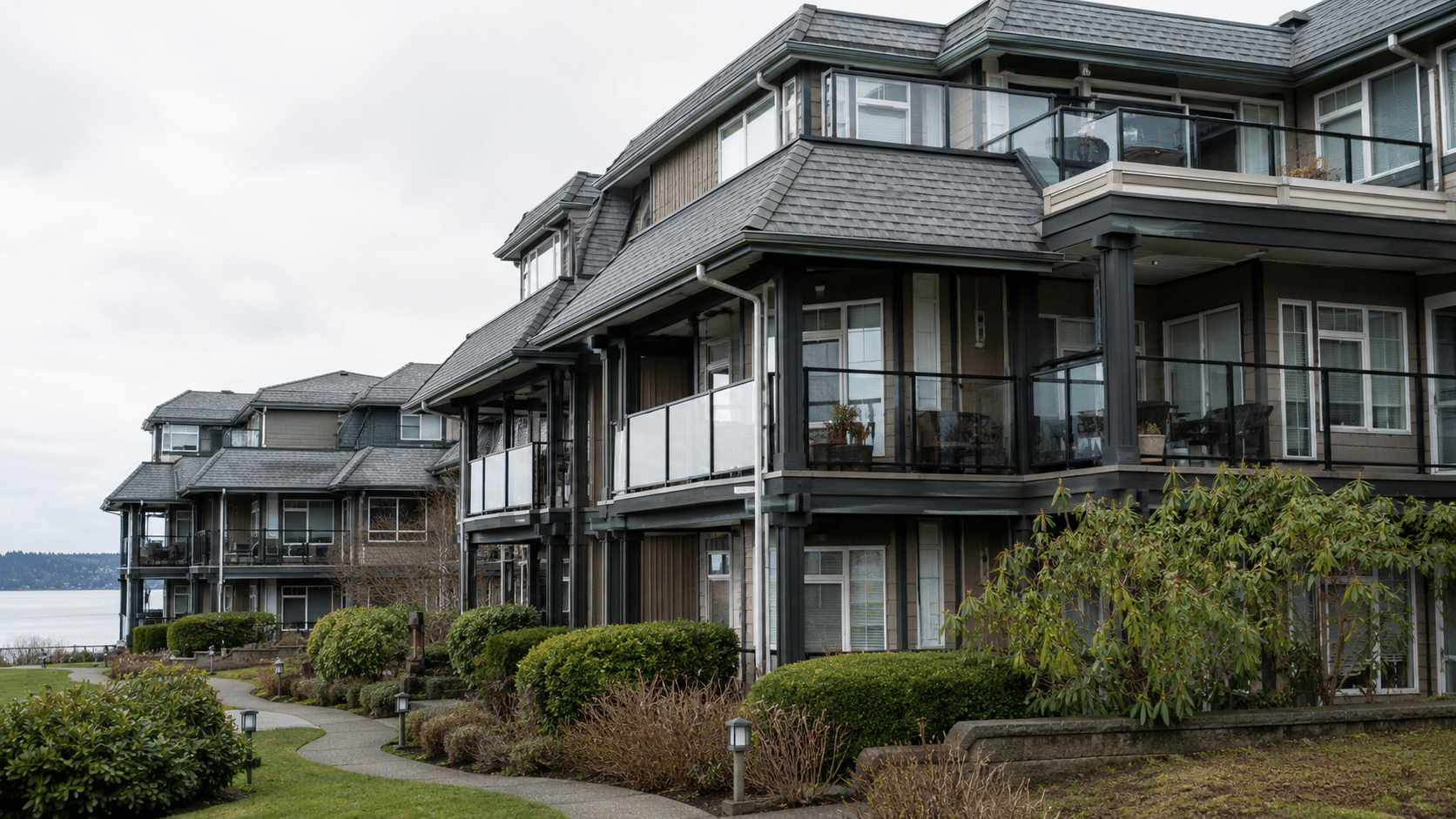 Low-rise strata building with roofs, windows, balconies, walkways, and landscaped areas.